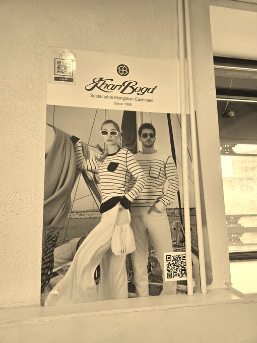 A poster for 'Khar Bogd - Sustainable Mongolian Cashmere Since 1998' featuring a man and woman in nautical attire, with QR codes visible.