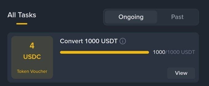 A dark blue interface showing "All Tasks" with an "Ongoing" tab, displaying a token voucher task "Convert 1000 USDT" at 1000/1000 USDT completion.