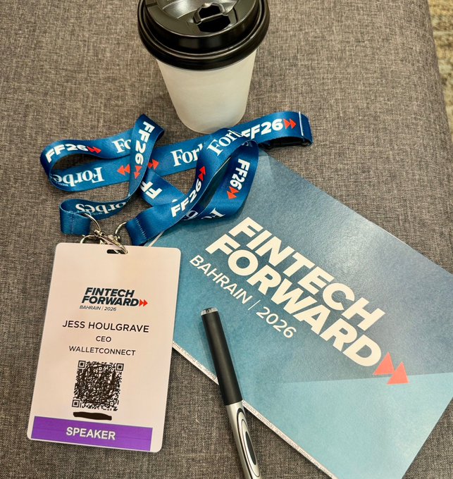 A conference badge and lanyard for "Jess Houlgrave, CEO, WalletConnect" labeled "Speaker" rest on a textured surface alongside a "FinTech Forward Bahrain | 2026" booklet, a pen, and a coffee cup, illustrating the WalletConnect CEO's arrival at the Fintech Forward event in Bahrain.