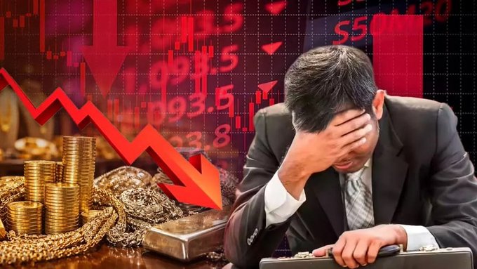 A man in a suit sits with his head in his hand in front of a briefcase and gold coins, with a red downward trending stock chart overlaid, depicting financial loss.