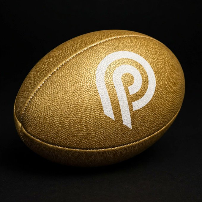 A gold, leather-textured football displays a white logo resembling a stylized 'P' against a black background.