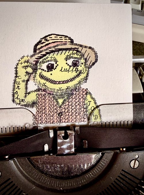 A piece of paper in a typewriter shows a cross-stitch style drawing of a character in a yellow hat with the repeated text '@noneofpiececept' filling the body, signed 'Lucia'.