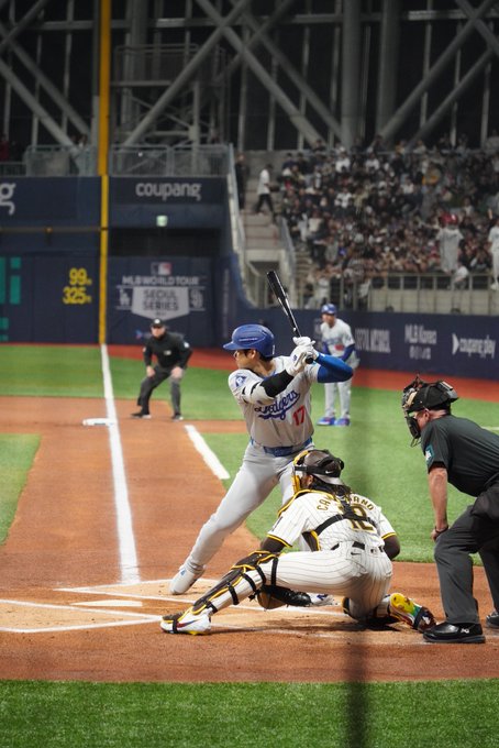 A batter awaits a pitch at home plate during an MLB World Tour Seoul Series game, with visible signage for "coupang," "MLB.TV," and a 99-325 scoreboard, fitting the post's context of a Polymarket wallet profiting over $554K from baseball predictions including bets on MLB teams like the Brewers, Mariners, Pirates, and Reds.