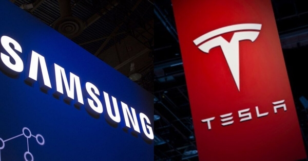 Illuminated Samsung and Tesla logos are displayed side by side on large vertical panels at an event or trade show.