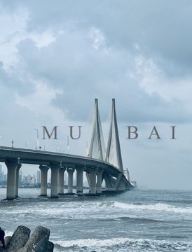 A vertical photo of the Bandra–Worli Sea Link in Mumbai with text overlay reading 'M U M B A I' across the cables.