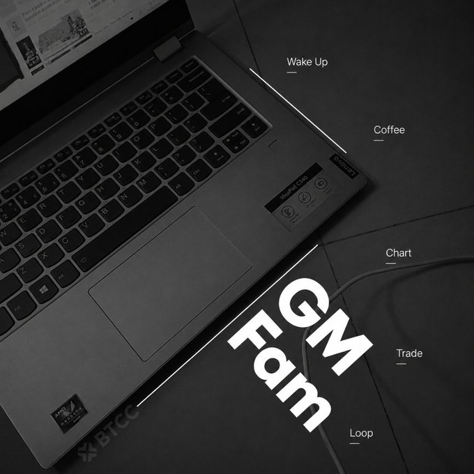 A black and white photo of an open BTCC branded laptop with text overlay reading 'GM Fam' along with a daily routine list: 'Wake Up, Coffee, Chart, Trade, Loop'.