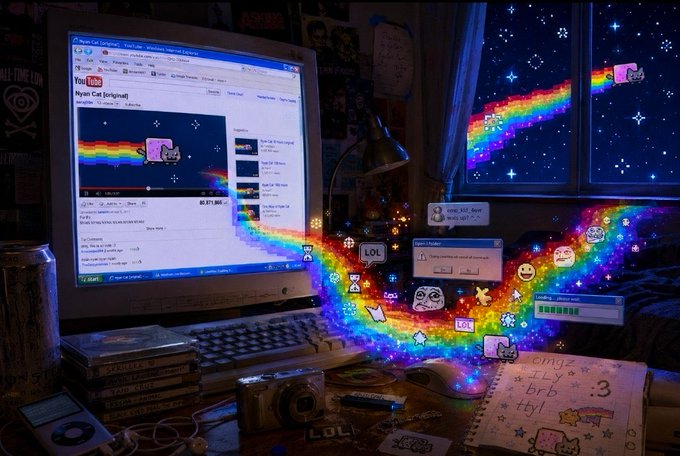 A nostalgic desk scene shows a computer monitor displaying a YouTube video titled 'Nyan Cat [original]', with the animated rainbow cat flying from the screen into the starry night window, surrounded by various meme stickers and objects.