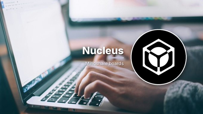 A promotional image for 'Nucleus - Mindshare boards' showing hands typing on a laptop with a black hexagonal cube logo in the upper right corner.