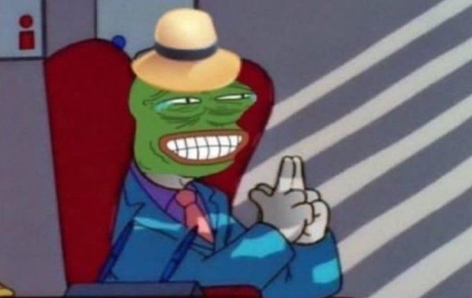 An animated character resembling a green frog-like figure wearing a tan hat, blue suit, and pink tie, grinning widely while seated in a red chair.
