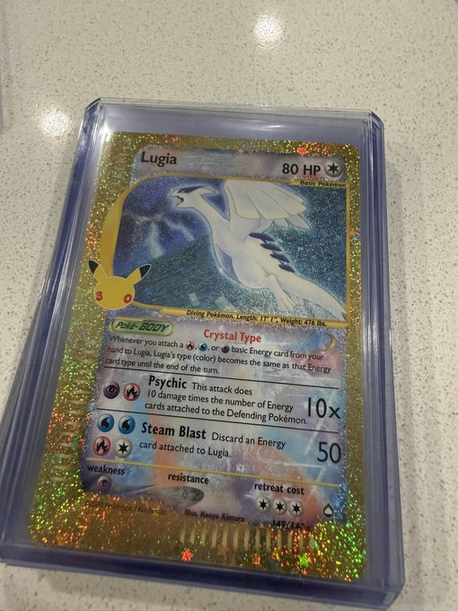 A holographic gold Pokémon trading card featuring Lugia with 80 HP, displaying attacks 'Psychic' (10x) and 'Steam Blast' (50), card number 149/147.