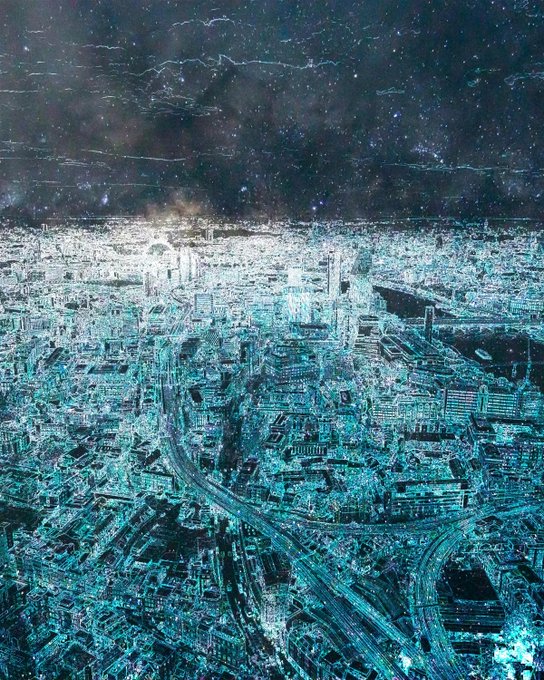 An aerial view of a city at night with an inverted color effect, showing illuminated buildings and a starry sky above the horizon.
