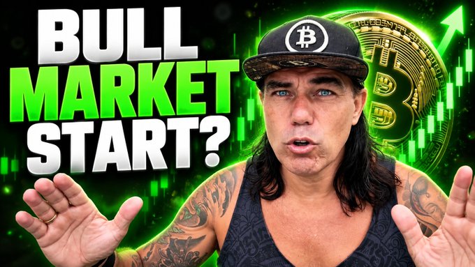 A YouTube-style thumbnail featuring a man with long hair and a Bitcoin hat with text reading 'BULL MARKET START?' against a green background with a Bitcoin and rising chart.