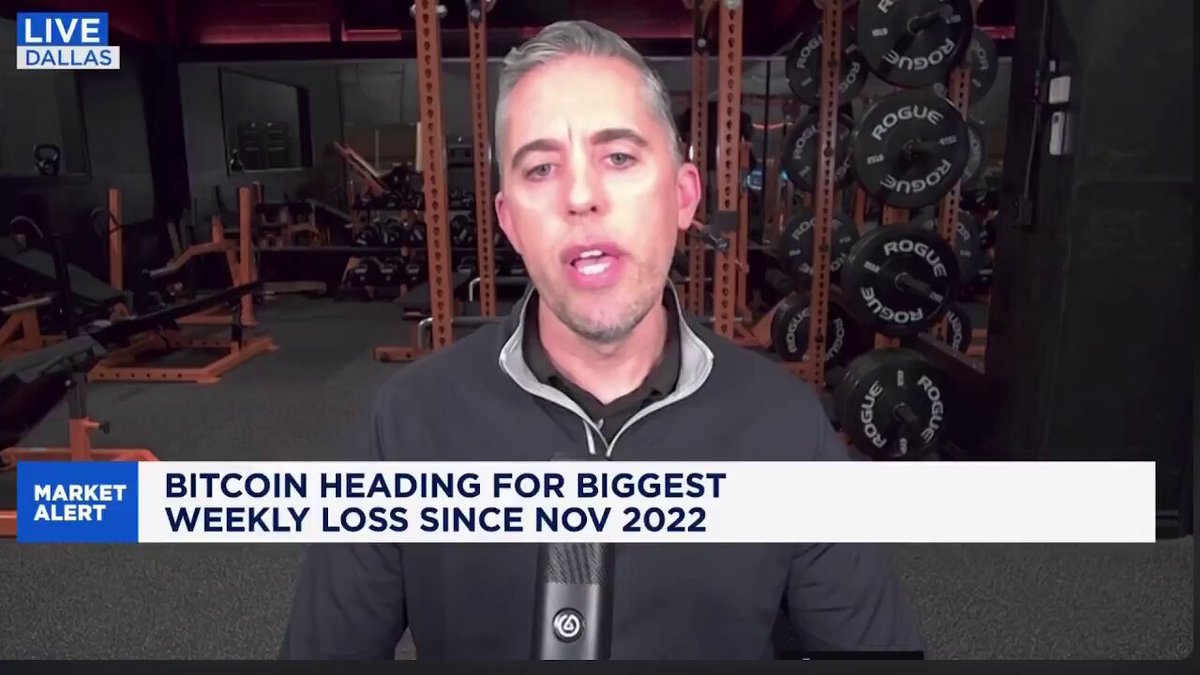 The image shows a man wearing a black jacket standing in front of a gym with various exercise equipment, including dumbbells and weight machines. The man appears to be giving a speech or interview about Bitcoin, which is displayed prominently at the top of the image.