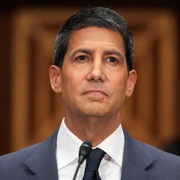 The image features a man wearing a suit, standing at a podium with his hands placed on a microphone. The caption of the image reads "HUGE: Kevin Warsh and Stellar co-founder David Mazières warn that America risks falling behind if it fails to embrace digital dollars and crypto." This statement is related to the man speaking into the microphone as he delivers a speech, suggesting that the topic of discussion could be about the importance of embracing digital currency or blockchain technology.

The image also includes other people in the background who are not visible due to their distance from the speaker. The focus on the man at the podium and his words emphasizes the significance of the message being conveyed by the speaker, which is likely related to the potential consequences of failing to adapt to digital currency and blockchain technology.