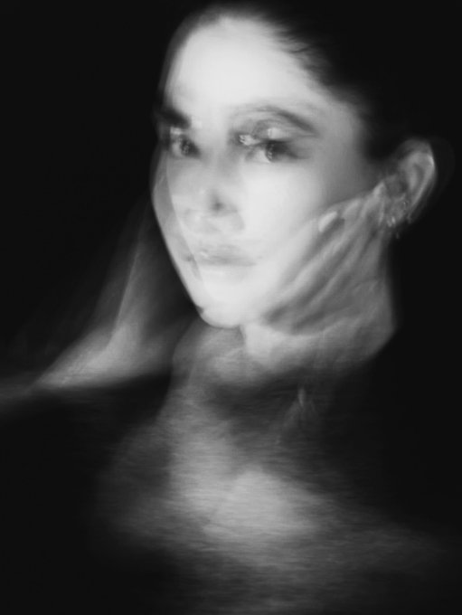 A moody black-and-white artistic portrait of a woman's face with dramatic lighting and a ghostly double-exposure effect, creating an ethereal atmosphere.