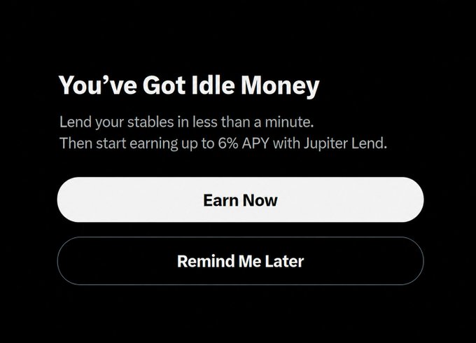 The image is a promotional pop-up from a financial app (likely X Money) with the headline "You've Got Idle Money," advertising up to 6% APY through Jupiter Lend, and features two call-to-action buttons: a white "Earn Now" button and a black "Remind Me Later" button. It relates to the post by showing a mobile interface prompt encouraging users to put their idle funds to work earning yield.