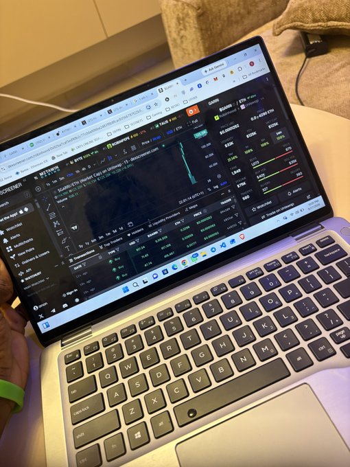 A laptop screen displays the Bitget cryptocurrency trading platform showing various market pairs and price charts.