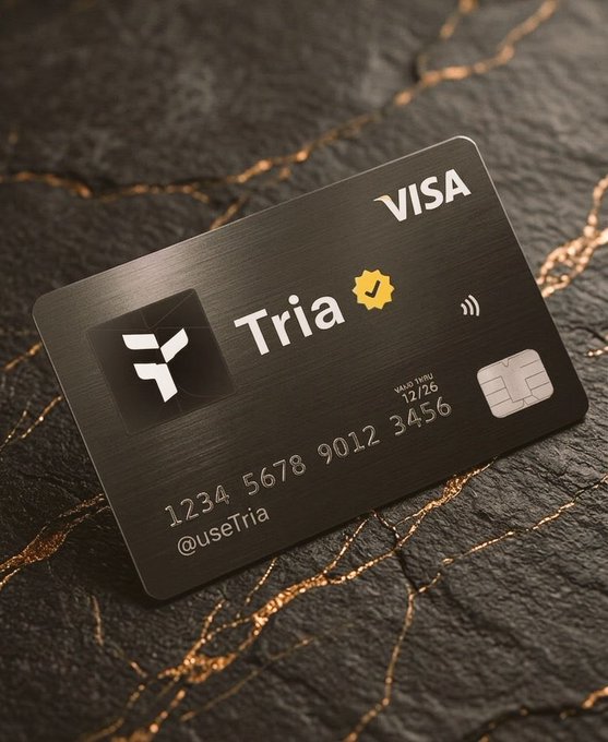 The image features a black credit card from Tria that has been placed on top of a rock or stone surface. The credit card is adorned with a yellow "Visa" logo, indicating its association with Visa payments. The text on the credit card reads "Tria", which stands for "Tria Credit Card". The credit card also displays the number "1234 567 878 912 343 1346 1347 1348 1349 1351 1352 1353 1355 1356 1357 1358 1359 1361 1362 1363 1364 1365 1366 1367 1368 1369 1371 1372 1373 1374 1375 1376 1377 1378 1379 1381 1382 1383 1384 1385 1386 1387 1388 1389 1391". The image also includes a caption that reads "Focus on what is in the image and how it relates to the post. @useTria is making crypto simple with self custody, smooth trading, yield opportunities, Visa card spending, gasless transactions, and full control of your assets".