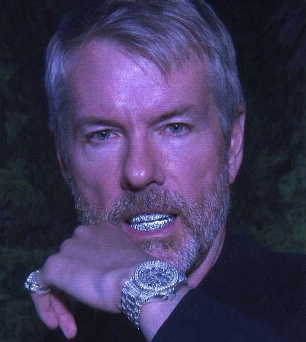 The image features a man with a beard wearing a black shirt who has a diamond-encrusted watch on his wrist, and he's holding up his hand over his mouth. The caption reads "Don' t listen to that absurd story about selling Bitcoin because of dividends". This statement is likely meant as a joke or humorous commentary on the absurdity of selling such a small amount of Bitcoin for dividends.