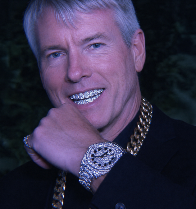 A silver-haired man in a black jacket poses confidently with a flashy diamond-encrusted watch and a thick gold chain, flashing a grill smile. The image perfectly embodies the post's joke about Michael Saylor's luxurious success while flexing his diamond watch—a symbol of his bullish Bitcoin gains compared to those who sold and missed out.