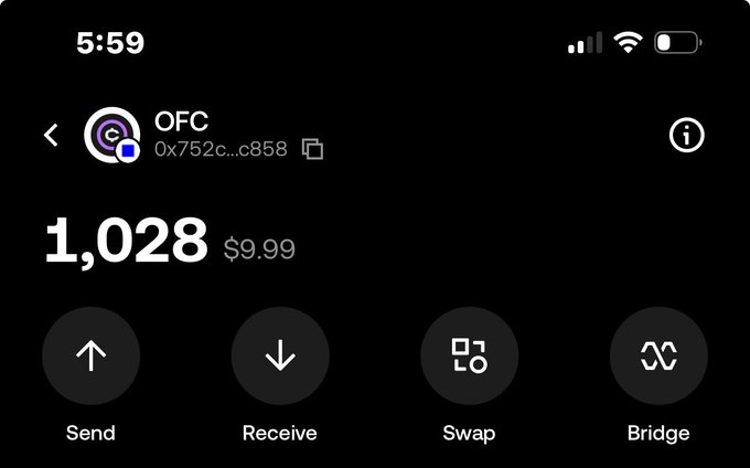 A mobile crypto wallet screenshot showing an OFC token balance of 1,028 (worth $9.99) with Send, Receive, Swap, and Bridge options, illustrating the user's modest holdings in the token they're hoping will increase in value.