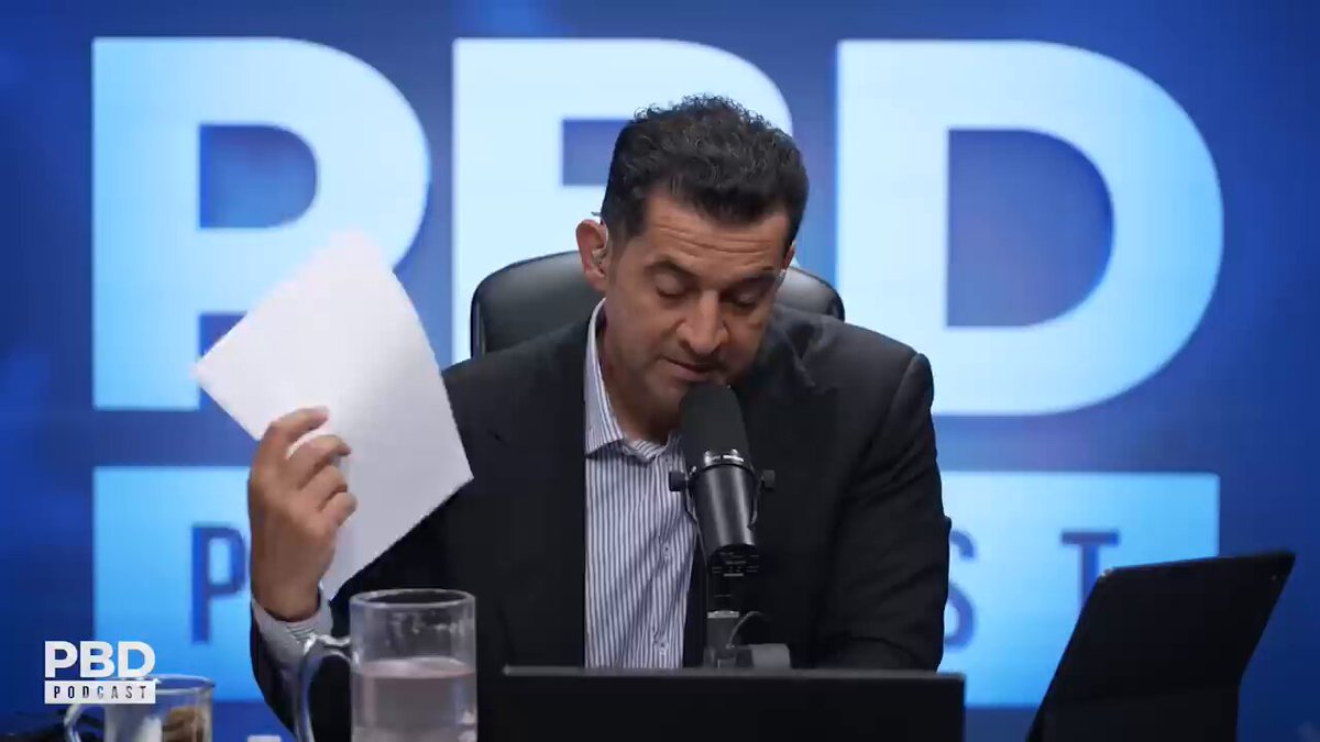 The image features a man sitting at a desk with a microphone, holding up a piece of paper or a sheet of paper. The background shows a blue wall with the words "PBD" written on it. The text in the image reads "Michael Saylor's LAST laugh", which is related to the post about Bitcoin and its potential crisis.