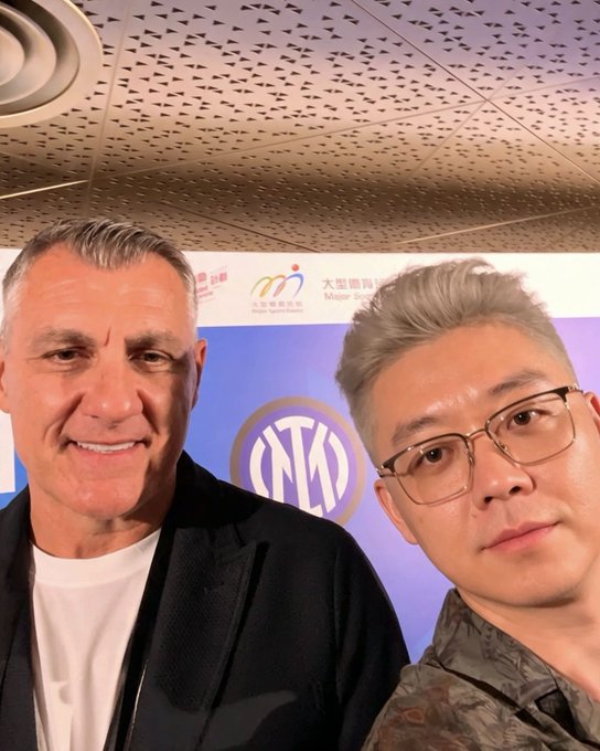 Former Inter Milan striker Christian Vieri poses for a selfie with a representative from OKX, a sponsor whose logo is visible on the backdrop, at what appears to be an Inter-related event in China.