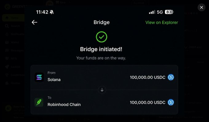 A mobile screenshot of a crypto bridge confirmation screen showing a successful 'Bridge initiated!' transfer of 100,000.00 USDC from Solana to Robinhood Chain, with a 'View on Explorer' link.