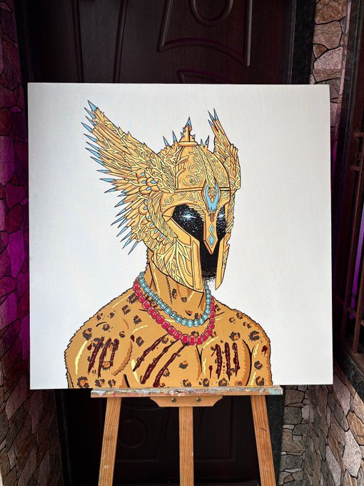 A detailed painting on canvas depicting a figure wearing an ornate golden helmet with wings and jewels, a black face mask, and red beaded necklaces, displayed on a wooden easel.