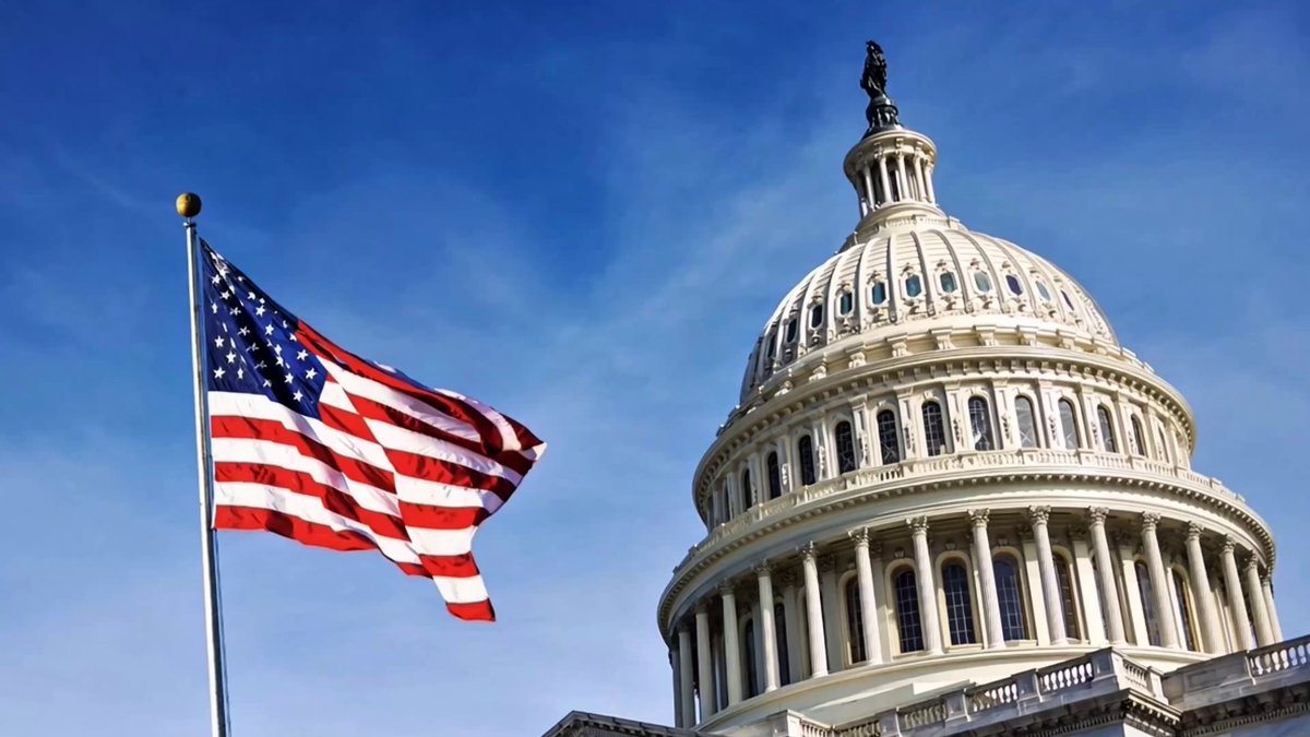 The image features an American flag flying next to a building, which appears to be the United States Capitol Building. The caption reads "Major News: The CLARITY Act is being introduced in the Senate today for consideration. This is a crucial step toward ending regulation by enforcement and establishing clear rules for cryptocurrency in the U.S.". The image also includes an American flag on top of the building, symbolizing patriotism and national pride.