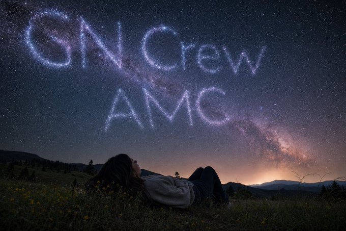 A person lies on grass gazing up at a starry night sky where stars spell out 'GNCrew AMG' above the Milky Way.
