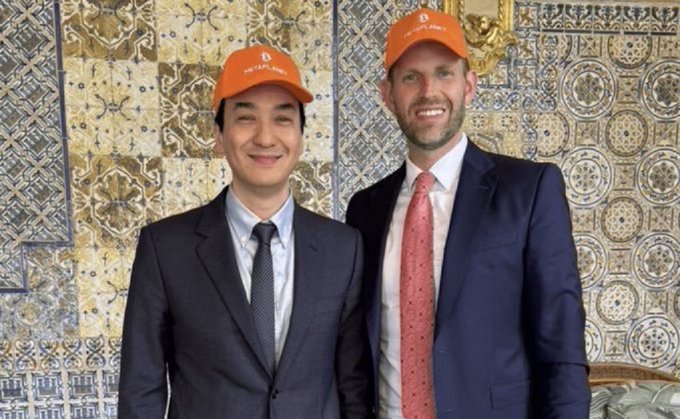 Two men pose side by side in suits and orange "Bitcoin Pizza" hats in front of an ornate tiled wall, with the post celebrating Metaplanet's $170 million Bitcoin purchase, reflecting the upbeat, bullish sentiment surrounding major corporate accumulation of Bitcoin.
