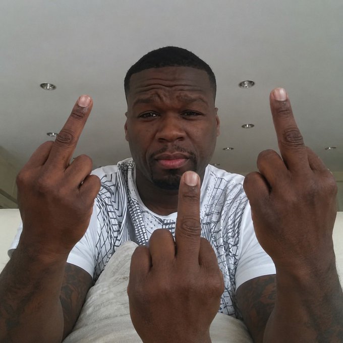 A close-up selfie shows a man looking at the camera while holding up both hands, extending his middle fingers.