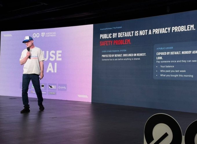 A speaker at the American Fortitude event delivers a presentation on stage, with a slide titled "PUBLIC BY DEFAULT IS NOT A PRIVACY PROBLEM. SAFETY PROBLEM." highlighting how exposed financial data—like balance, recent payments, and purchase history—poses risks that require user-disclosed protection rather than default transparency, reinforcing the post's message about the need for transactional privacy in crypto.