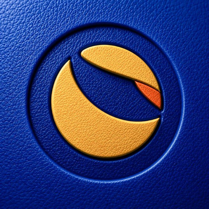 A close-up of a yellow and orange crescent logo embossed on a textured blue leather surface.