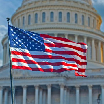 The image features a large American flag flying high above the Capitol building, which serves as an iconic symbol of the United States government. In the background, there are columns visible behind the flag, further emphasizing its significance. The caption provided in the image suggests that this is a significant event or gathering related to the Institute for Policy Innovation (IPI), and it appears to be taking place at the Capitol building in Washington DC.

The presence of the American flag flying above the Capitol building signifies patriotism and national pride, while also highlighting the importance of the Institute's work in shaping public policy and informing decision-making processes.