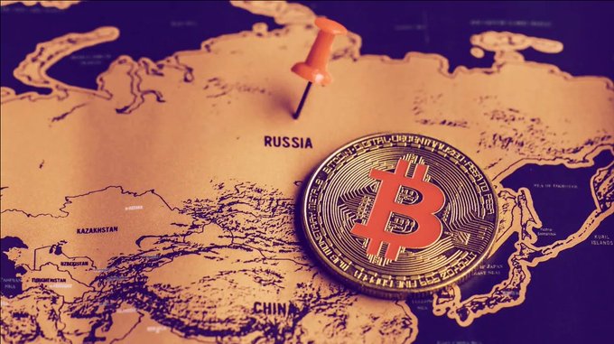 A physical Bitcoin coin pinned to a map of Asia near Russia and China, symbolizing cryptocurrency's geographic influence.