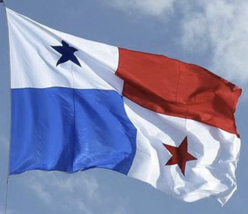 The national flag of Panama waving against a blue sky with scattered clouds, displaying its quartered design with two blue and two white sections featuring a star in each.