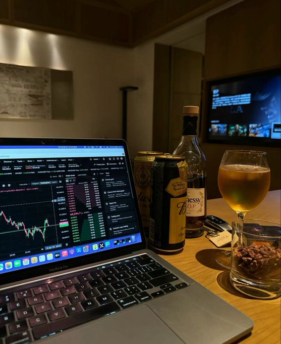 The image shows an open laptop computer sitting on top of a wooden table with various items placed around it. There are two bottles of alcohol, one near the center of the table and another towards the right side. A glass filled with beer can be seen in front of the laptop. The scene also includes a TV mounted on the wall behind the table.

The image is related to the post because it features an analysis of the market's trading activity using a laptop computer, which is likely discussing the impact of vaporware and sybil farms on retail investors.
