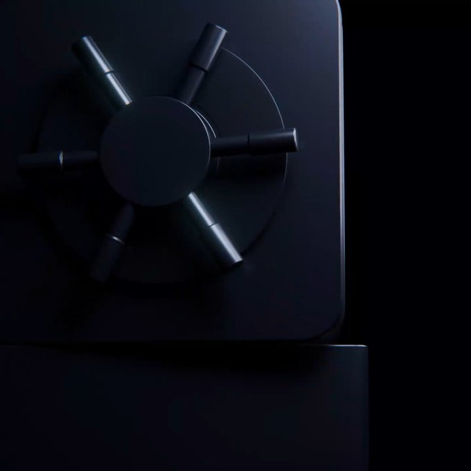A dark, close-up shot of a black combination lock dial on what appears to be a safe, symbolizing secrecy and anticipation. The image relates to the post by visually representing the mystery surrounding Uphold's teased but unrevealed announcement for XRP, hinting that the details are still "locked away."