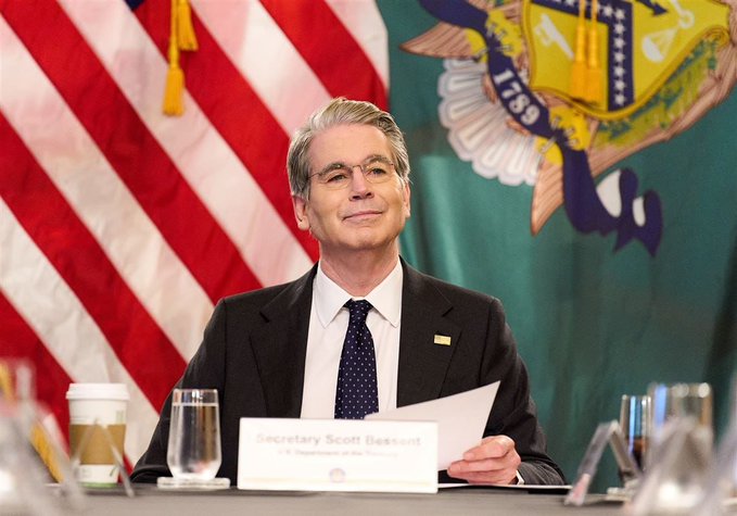 Secretary Scott Bessent of the U.S. Department of the Treasury is shown seated at a desk during a meeting, with the Department of the Treasury seal visible behind him.
