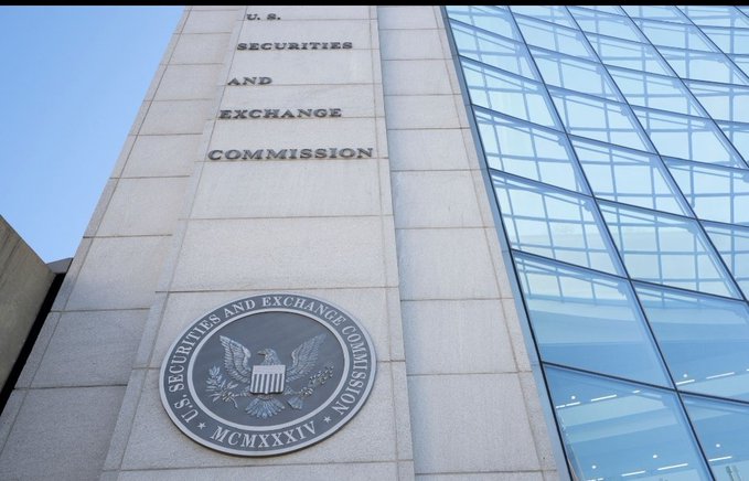 An upward view of the U.S. Securities and Exchange Commission (SEC) building, showing the agency name engraved on the stone facade above its official seal, which bears an eagle and the Roman numerals 'MCMXXXIV' (1934).
