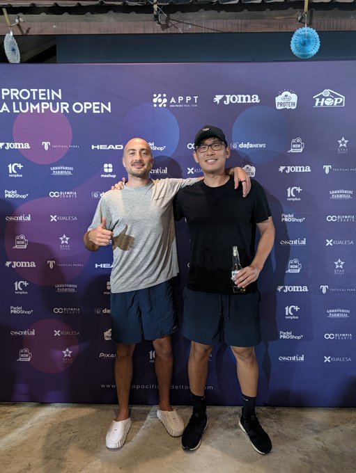 Two men pose in front of a sponsor backdrop for the "PROTEIN KUALA LUMPUR OPEN" event, which features logos for brands like Joma, Head, Apollo, and Essential.