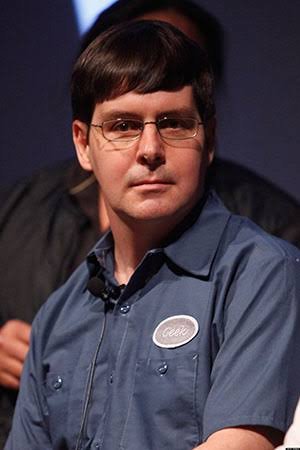 A man with glasses and dark hair wearing a blue shirt with a "Gavin" name badge sits attentively, identified in the accompanying post as Gavin Andresen, a Bitcoin developer referenced in the tweet praising his integrity for refusing to meet Epstein and noting his ousting by Core developers.