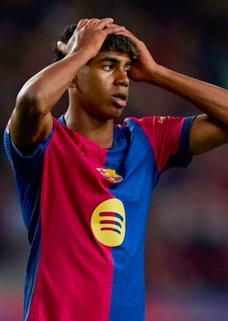 A Barcelona player, wearing the club's iconic blue and claret jersey with the Spotify sponsor logo, holds his head in apparent frustration or disbelief on the pitch, capturing the tension surrounding a high-stakes $65,000 bet against Barcelona winning their match against Sevilla on Polymarket.