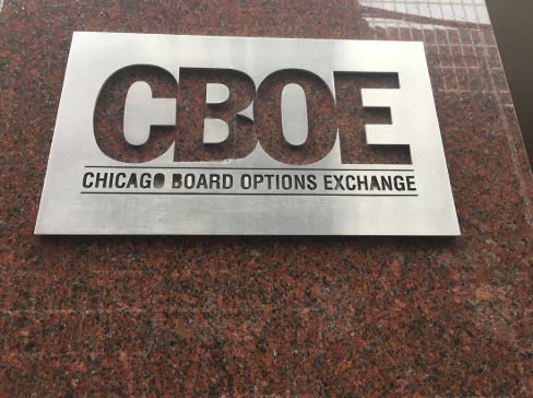 A metal plaque engraved with 'CBOE' and 'CHICAGO BOARD OPTIONS EXCHANGE' mounted on a red granite surface.