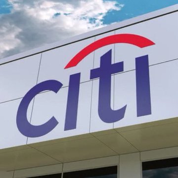 A Citi (Citigroup) sign is mounted on the side of a building under a partly cloudy sky. The image illustrates the accompanying news that Citi, the U.S. banking giant, plans to launch a Bitcoin custody service.