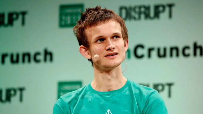 Vitalik Buterin, co-founder of Ethereum, speaks at a TechCrunch Disrupt event while wearing a teal shirt and headset microphone. The backdrop's "DISRUPT" and "Crunch" branding frames him as he discusses his new privacy-focused AI agent setup integrating zkAPI, Tor, and local LLMs.