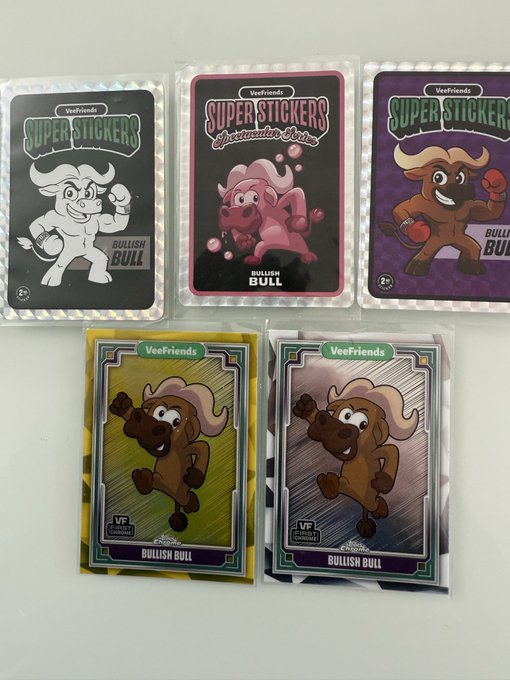 The image shows a collection of five trading card sets featuring cartoon bull characters from various companies such as GM GM, Super Stickers, and Bullish Friends. The cards are neatly arranged next to each other with their unique designs and colors. The post about trading card games emphasizes the importance of every project having its own lane in terms of content and audience. It also highlights the variety of projects that can be included within a single collection or series.