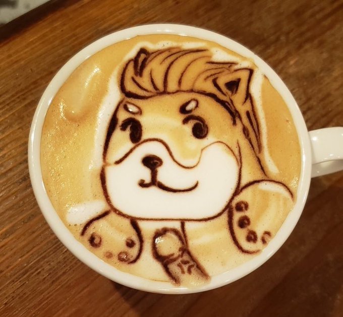 An intricate latte art design in a white cup depicts a cute cartoon Shiba Inu dog face with detailed chocolate syrup line work.